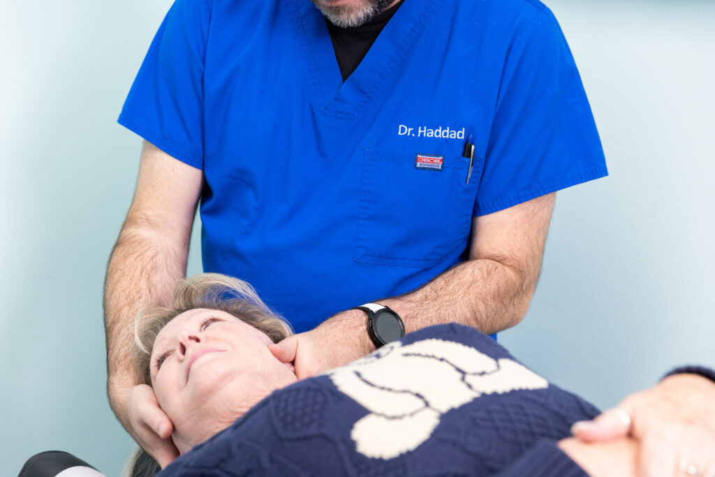 Patient lies down on table as a neck specialist in North Liberty adjusts her neck to help find relief from pain